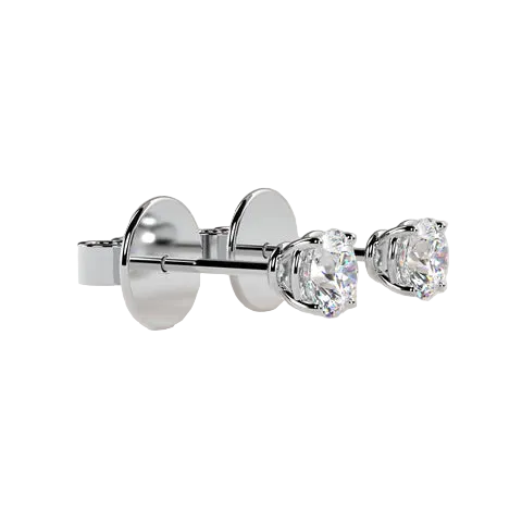 A pair of silver stud earrings with round clear gemstones, shown from a side angle against a solid light beige background.