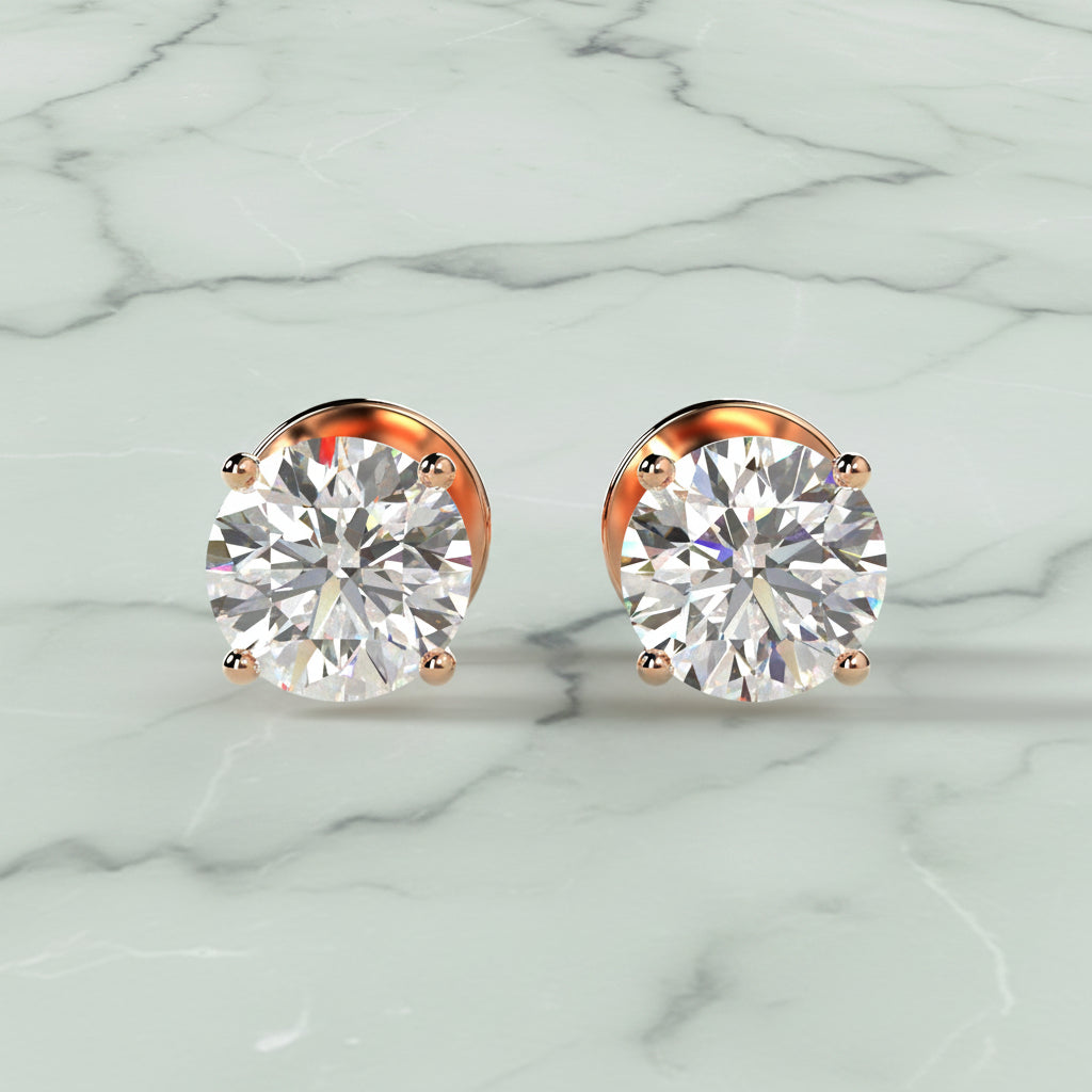 Pair of diamond stud earrings on a light beige background