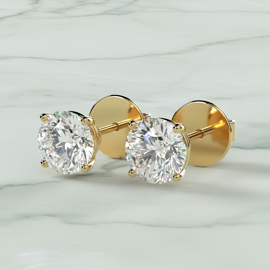 Gold earrings with clear gemstones on a beige background