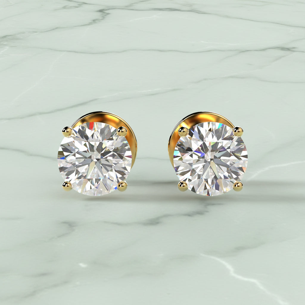 Gold earrings with clear gemstones on a beige background
