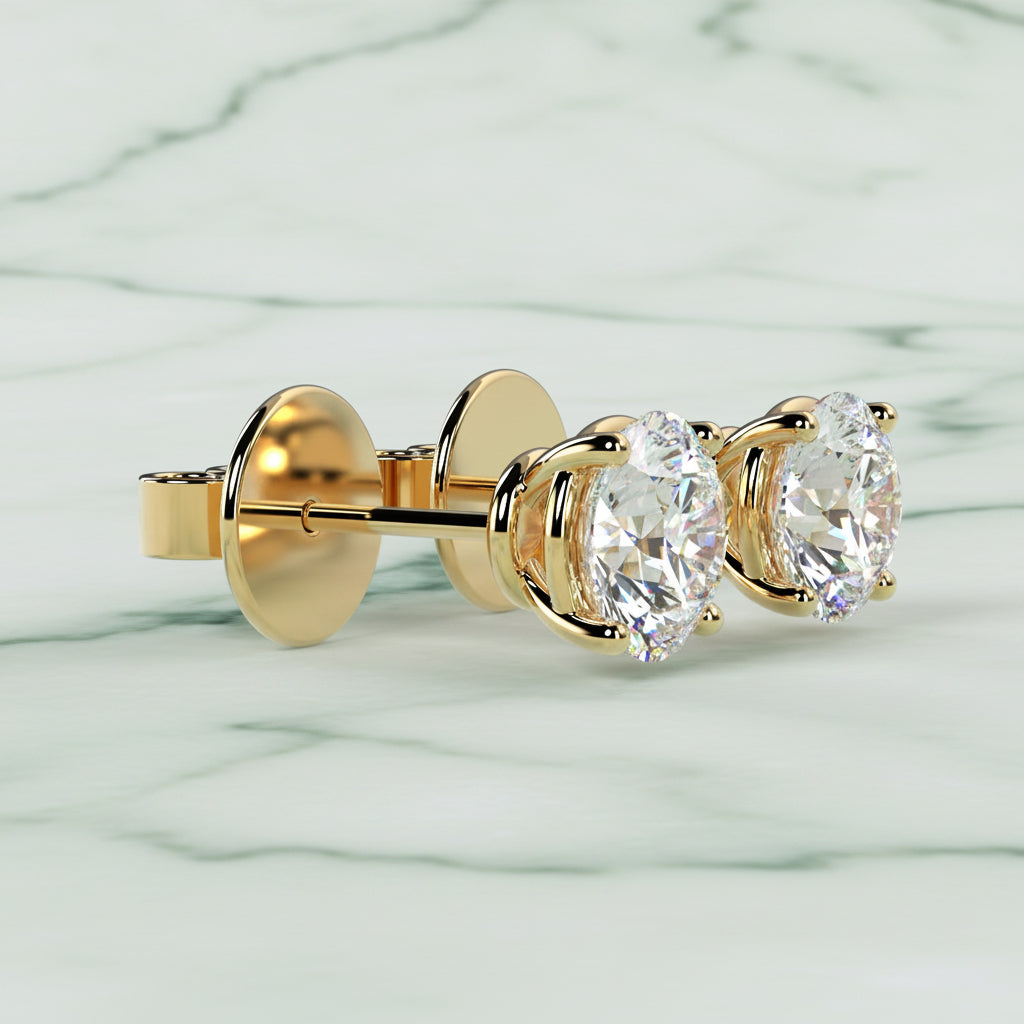 Gold earring with two clear gemstones on a beige background