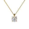 A yellow gold solitaire necklace with a round brilliant-cut diamond pendant, shown against a solid light beige background.