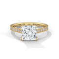 Gold ring with a large diamond and smaller diamonds on the band against a white background