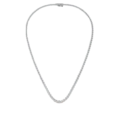 A delicate silver tennis necklace with a continuous line of small clear stones, displayed in a teardrop shape against a solid pale pink background.