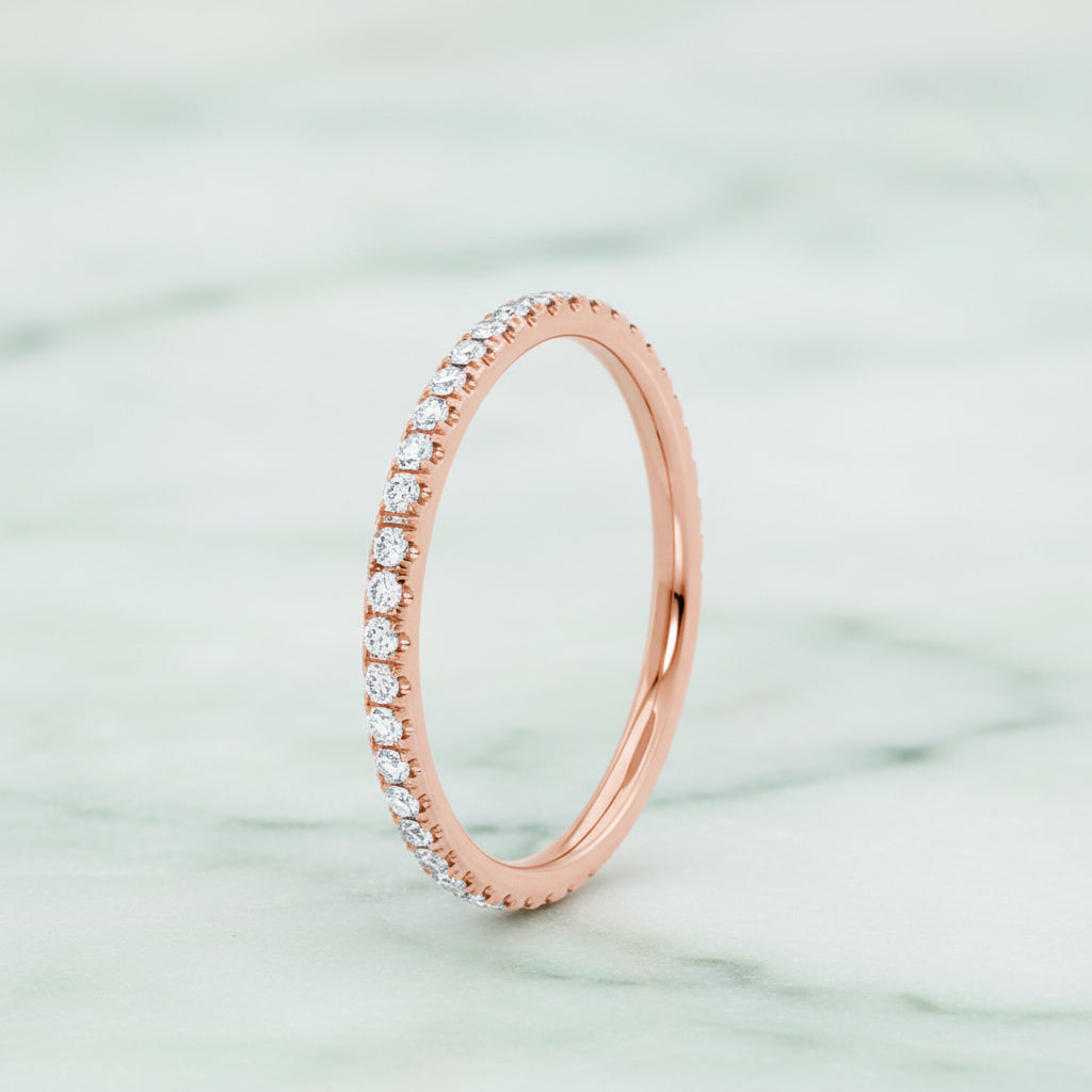 Rose gold ring with diamonds on a white background