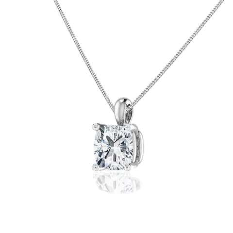 A silver solitaire pendant necklace featuring a brilliant round-cut clear gemstone in a four-prong setting, suspended from a delicate silver chain against a white background with a soft reflection below.