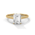 Gold ring with a rectangular diamond on a white background
