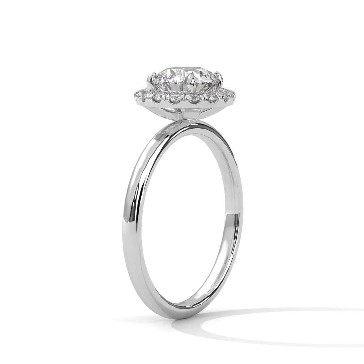 A silver-toned halo engagement ring featuring a round-cut center stone surrounded by a halo of smaller round stones, set on a polished band and shown against a white background.