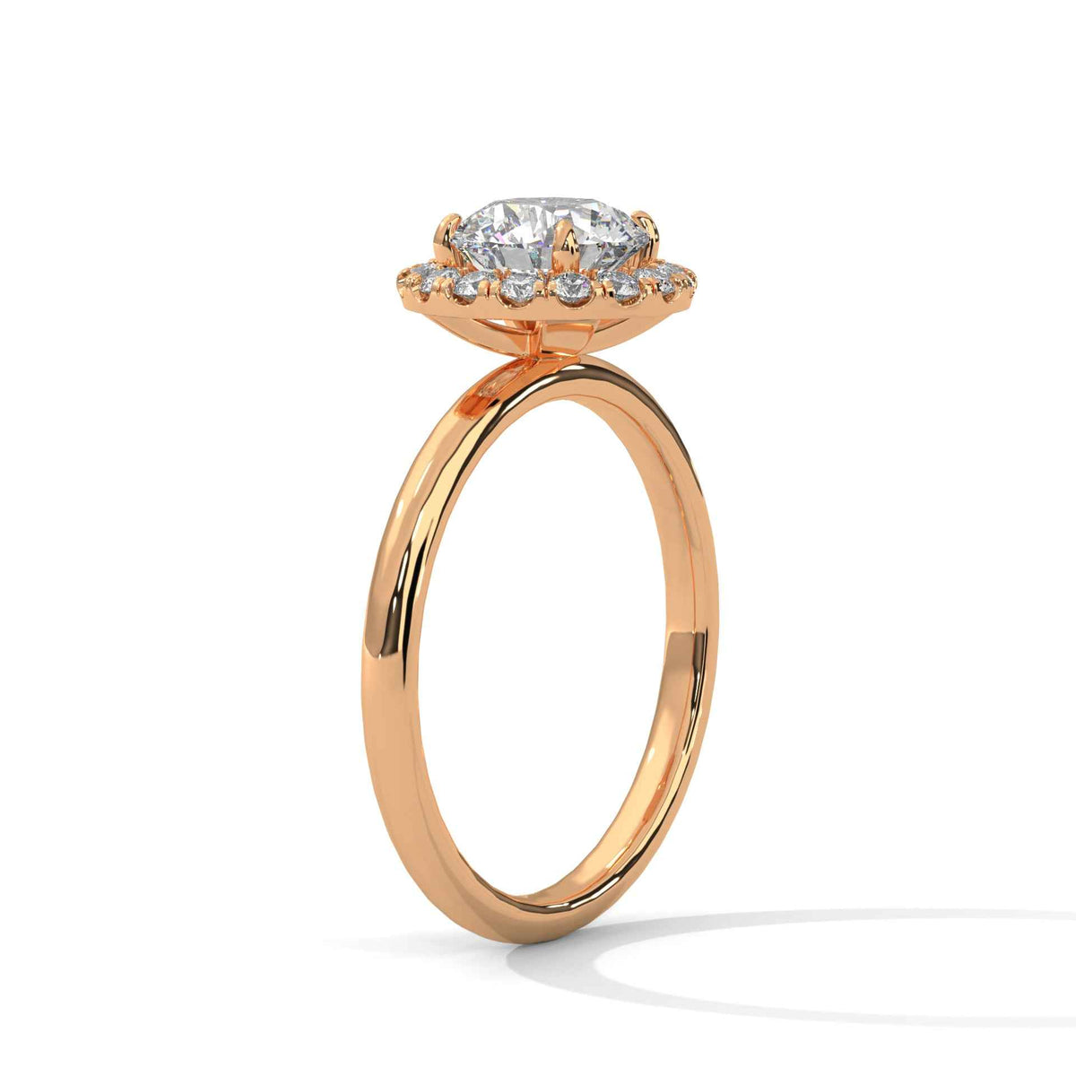 A rose gold ring with a large round-cut center stone and a halo of smaller side stones, shown on a clean white background.