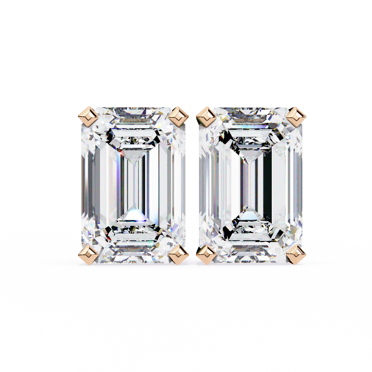 Pair of emerald-cut diamonds with rose gold prongs on a white background