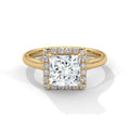 Gold ring with a large diamond and smaller diamonds on the band against a white background