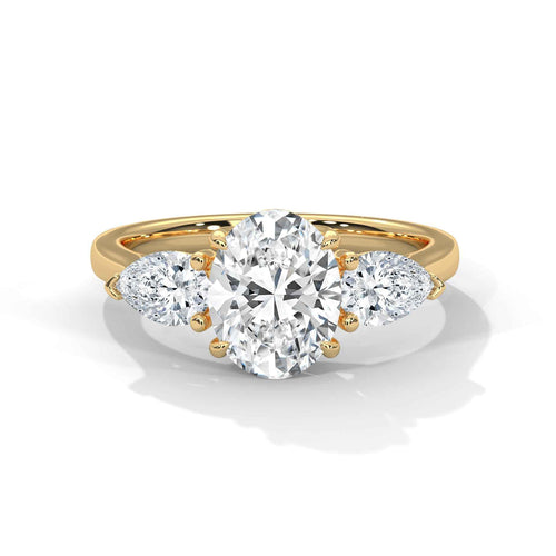 Gold ring with a heart-shaped diamond and smaller side stones on a white background
