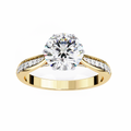 Gold ring with a large diamond and smaller diamonds on the band against a white background