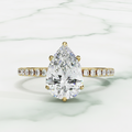 Diamond ring with a pear-shaped center stone on a white background