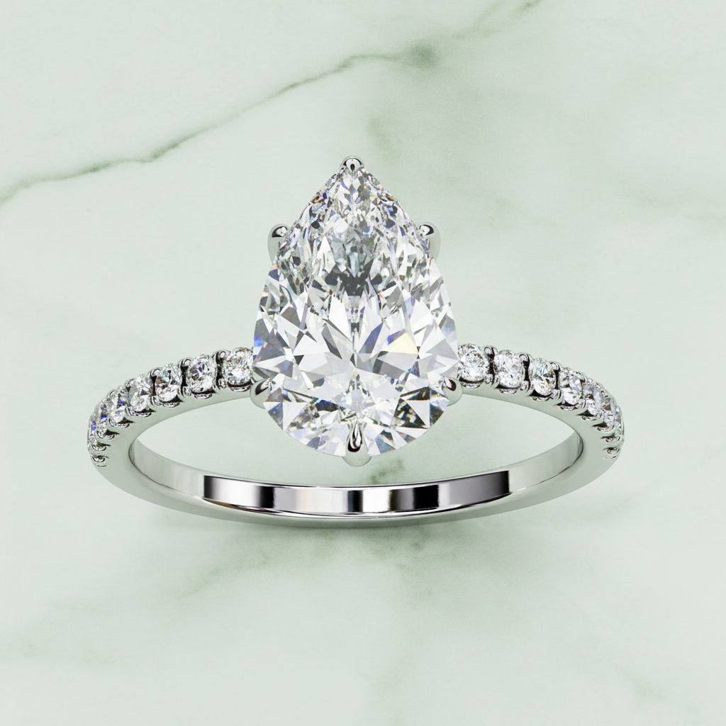 Diamond ring with a pear-shaped center stone on a white background