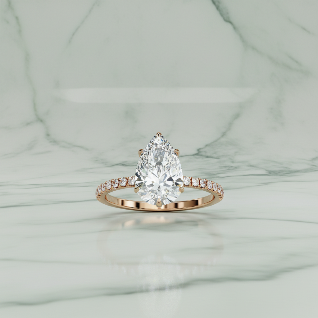 Rose gold ring with a pear-shaped diamond on a white background